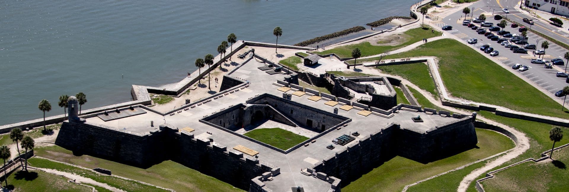 Aerial view of a historical fort surrounded by water and greenery.