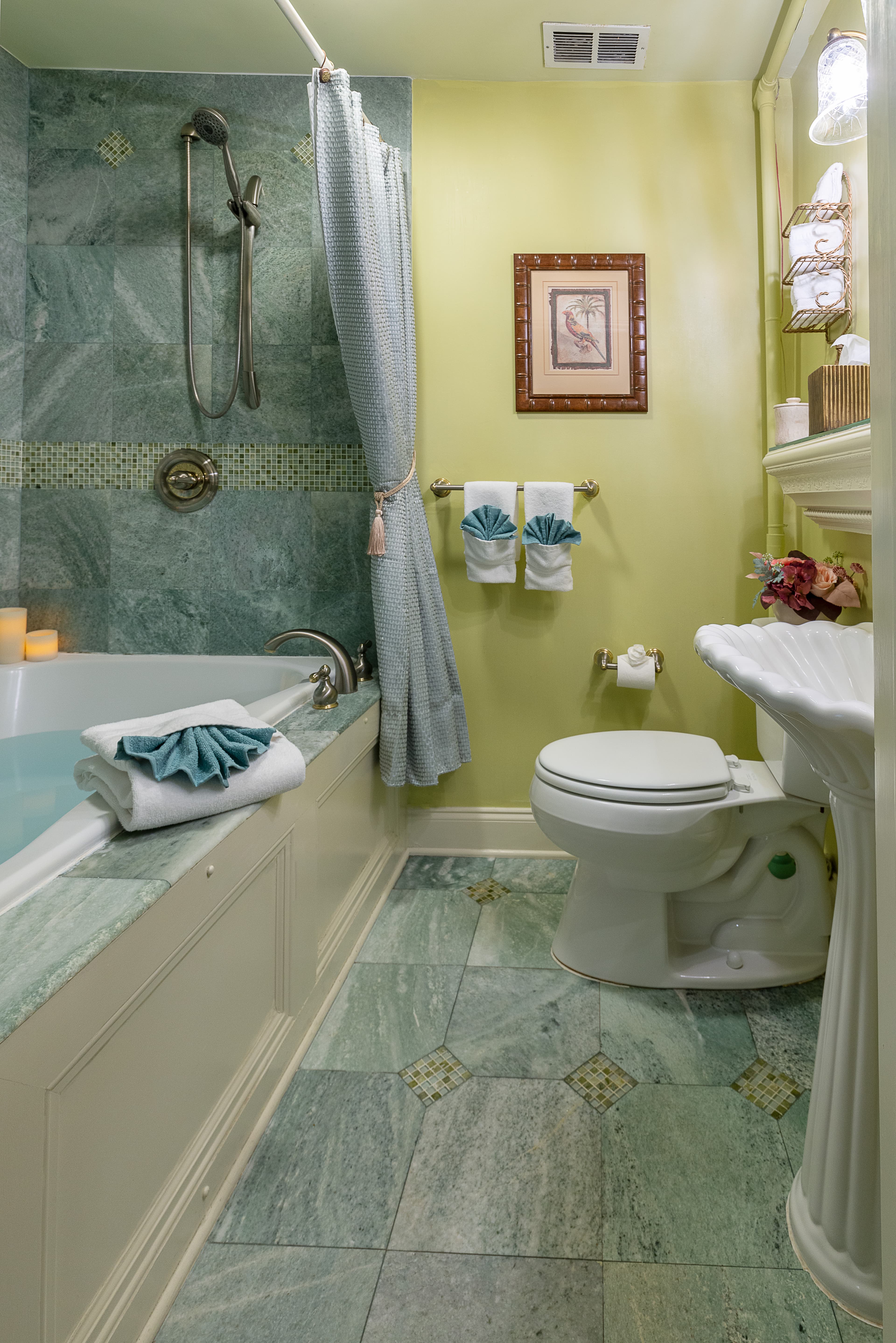 A small bathroom with a shower/tub combo, a toilet, and a pedestal sink.