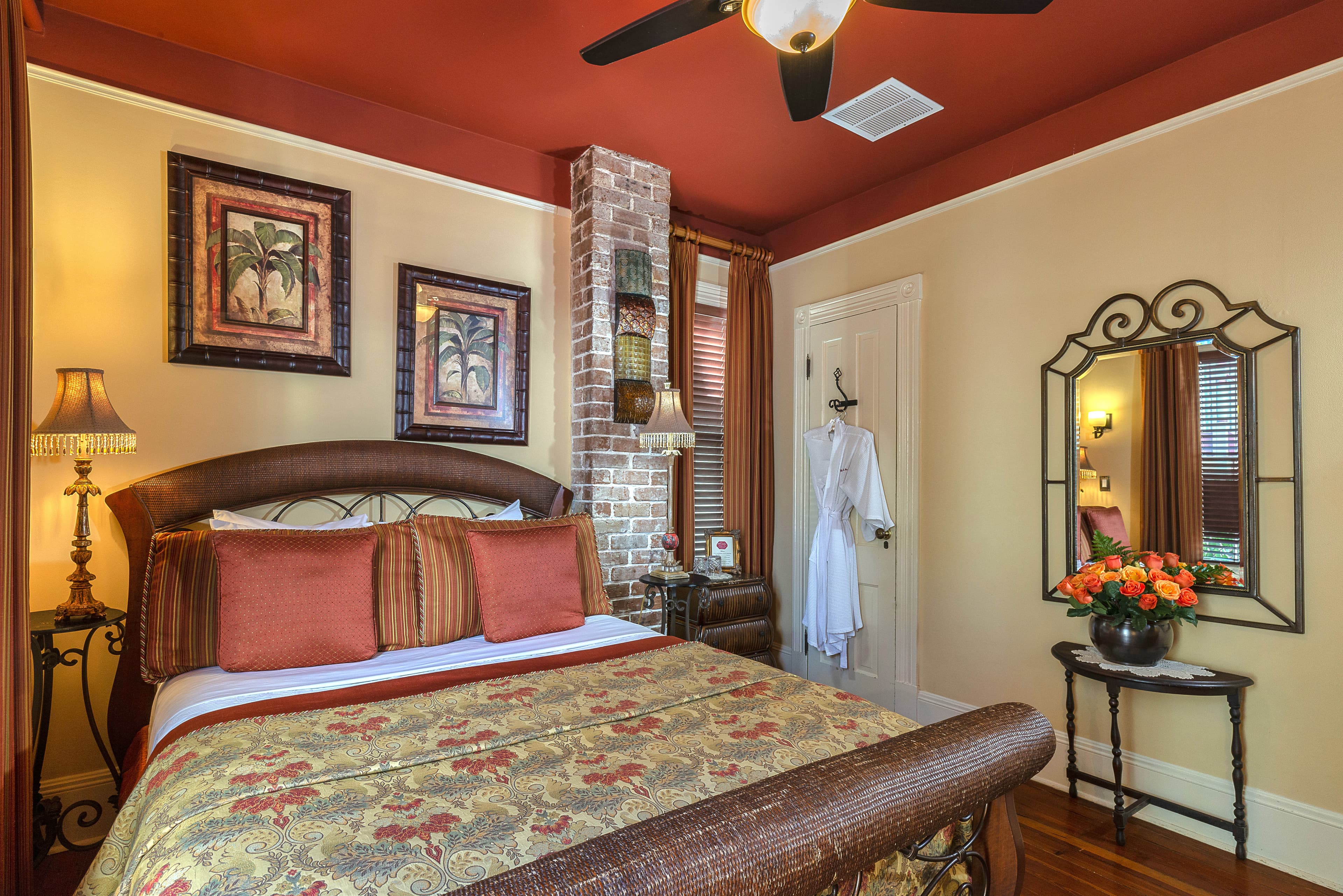 featuring a bed with a patterned comforter and pillows, a sitting area with a chair and a lamp.